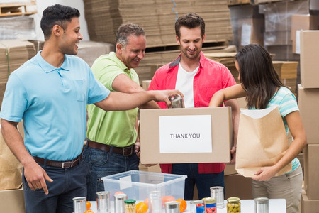 Warehouse workers packing up donation boxes in a large warehouseの写真素材