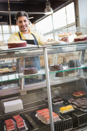 Portrait of smiling worker behind the dessert at the bakeryの写真素材