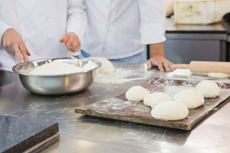 Colleagues working together on worktop in the kitchen of the bakery