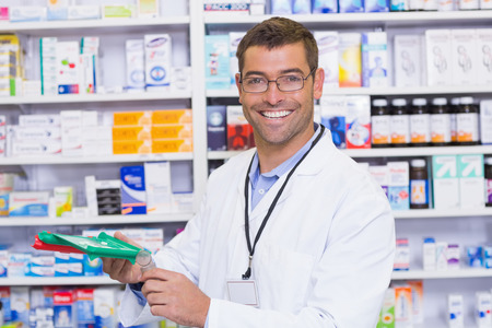 Handsome pharmacist holding medicine at the hospital pharmacyの写真素材