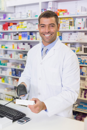 Handsome pharmacist scanning medicine box at the hospital pharmacyの写真素材