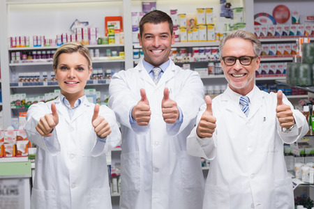 Team of pharmacists smiling at camera at the pharmacyの写真素材