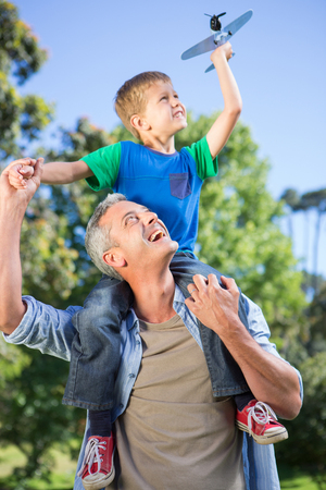 Father and son having fun in the park on a sunny dayの写真素材