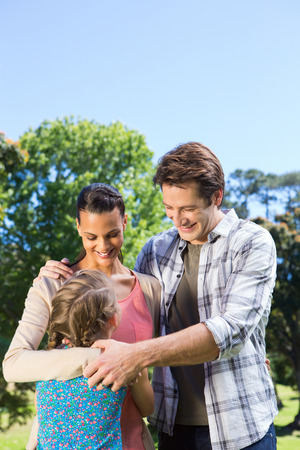 Happy family in the park together on a sunny dayの写真素材