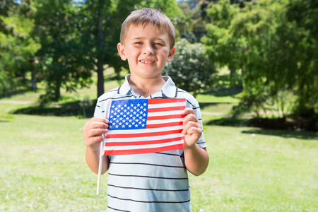 Little boy waving american flag on a sunny dayの写真素材