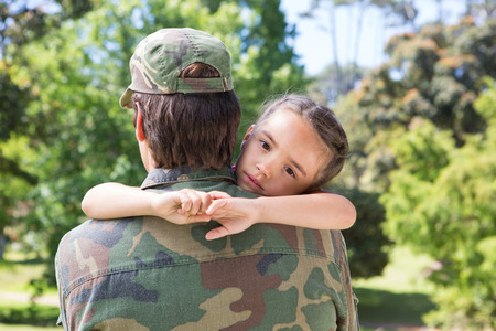 Soldier reunited with his daughter on a sunny dayの写真素材