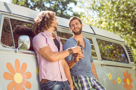 Hipster friends toasting with beers on a summers day