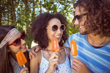 Hipster friends enjoying ice lollies on a summers dayの写真素材