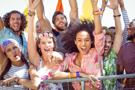 Excited young people singing along at a music festivalの写真素材