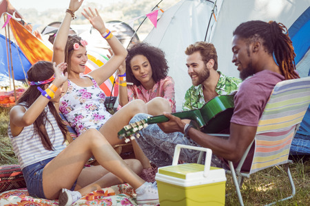 Hipsters having fun in their campsite at a music festivalの写真素材
