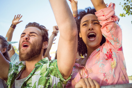 Excited young people singing along at a music festivalの写真素材