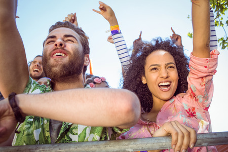 Excited young people singing along at a music festivalの写真素材