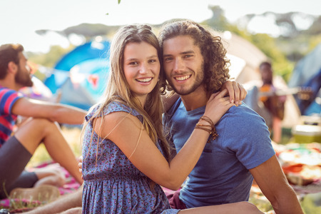 Hipster couple smiling at camera at a music festivalの写真素材