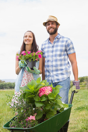 Happy young couple gardening together on a sunny dayの写真素材