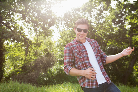 Handsome hipster playing air guitar on a sunny dayの写真素材