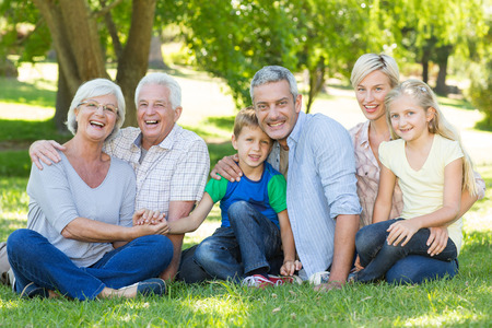Happy family smiling at the camera on a sunny day