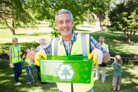 Happy father holding recycling case on a sunny dayの写真素材