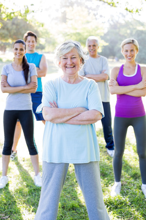 Happy athletic group with arms crossed on a sunny dayの写真素材