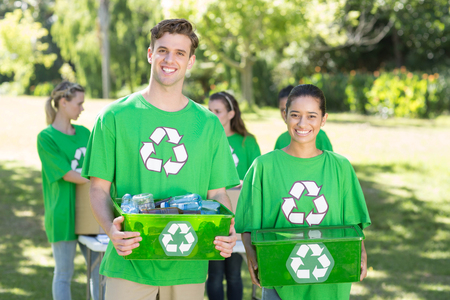 Happy environmental activists in the park with recyclables  on a sunny dayの写真素材