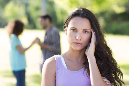 Woman upset at her crush with other girl on a sunny dayの写真素材