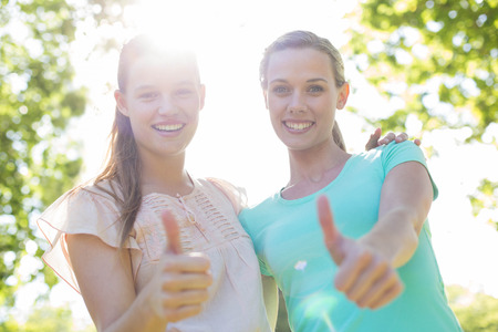 Happy friends smiling in park on a sunny dayの写真素材
