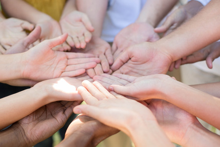 Friends putting their hands together on a sunny dayの写真素材