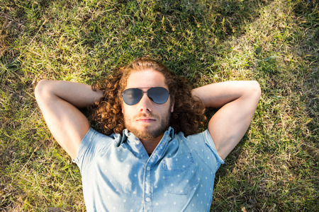 Young man lying down in the park on a summers dayの写真素材