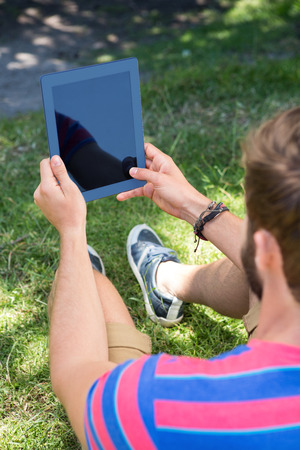 Man using tablet in the park on a summers dayの写真素材