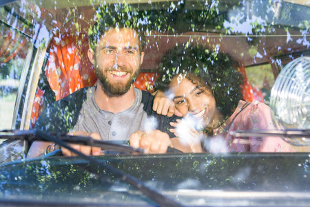 Hipster couple driving in camper van on a summers day