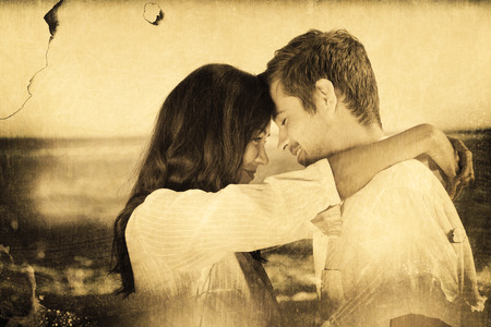 Couple embracing each other on the beach against grey backgroundの写真素材