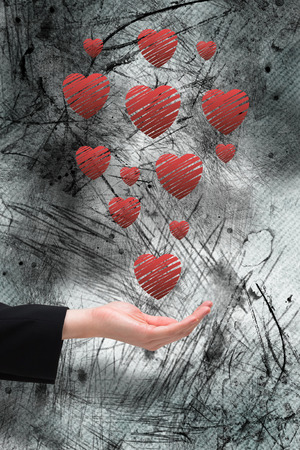 Businesswomans hand presenting against heartの写真素材