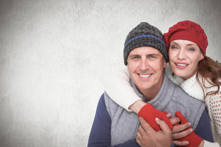 Happy couple in warm clothing against white backgroundの写真素材