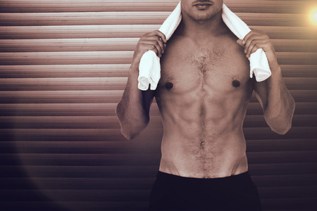 Fit shirtless man looking at camera against grey shuttersの写真素材