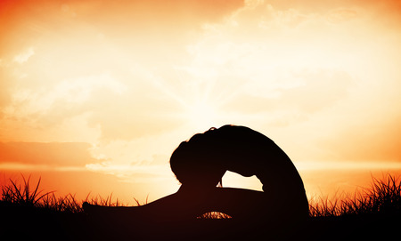 Gorgeous fit blonde in seated forward bend pose  against orange sunriseの写真素材