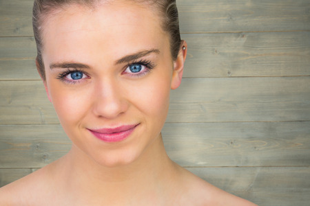 Smiling blonde natural beauty against bleached wooden planks backgroundの写真素材