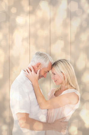 Affectionate couple standing and hugging against light glowing dots design patternの写真素材