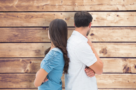 Upset couple not talking to each other after fight against wooden planks backgroundの写真素材