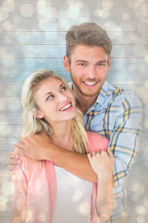 Attractive young couple smiling together against light glowing dots design patternの写真素材