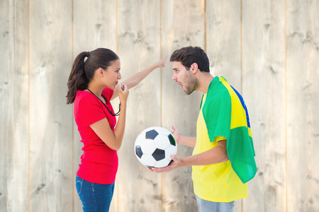 Brunette sending off a brazilian fan  against pale wooden planksの写真素材
