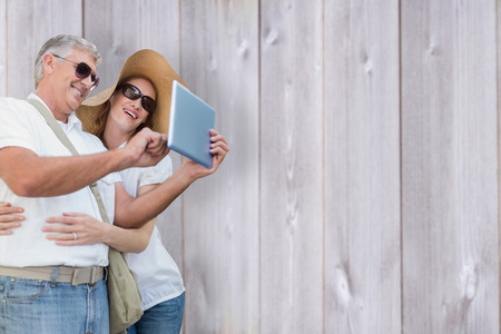 Vacationing couple taking photo against wooden backgroundの写真素材