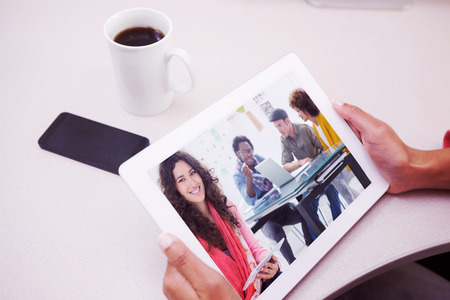 Composite image of smiling designer using tabletの写真素材