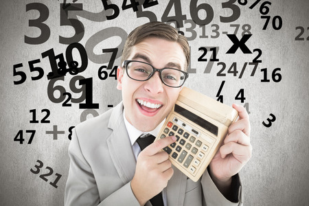 Geeky smiling businessman showing calculator against white backgroundの写真素材