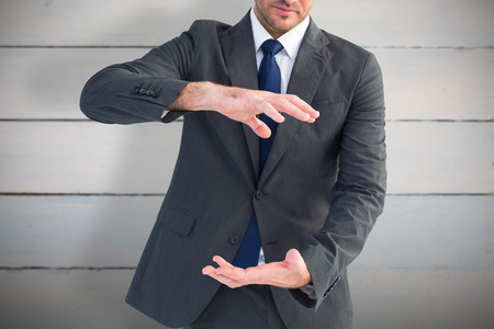 Businessman gesturing with his hands against painted blue wooden planksの写真素材