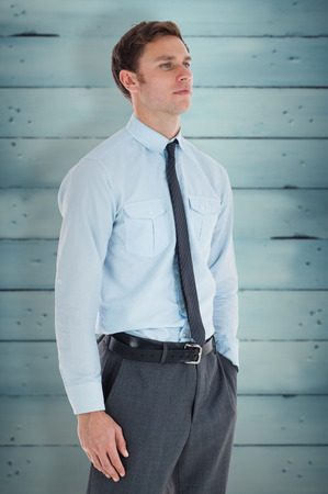 Serious businessman standing with hand in pocket against wooden planksの写真素材