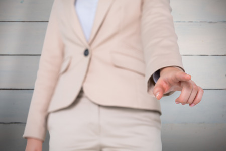 Businesswoman pointing against painted blue wooden planksの写真素材