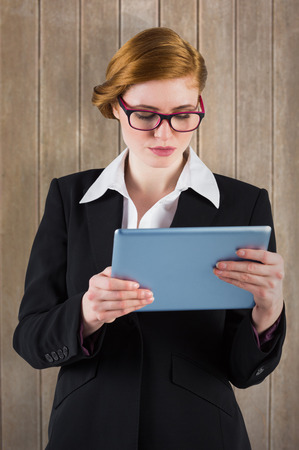 Redhead businesswoman using her tablet pc against wooden surface with planksの写真素材