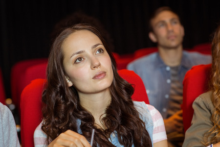 Young friends watching a film at the cinema
