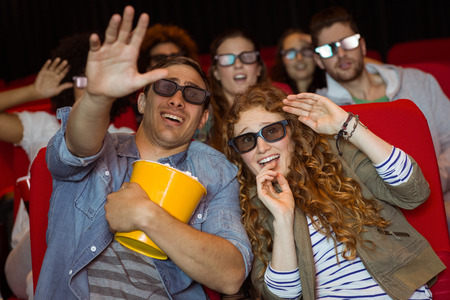 Young friends watching a 3d film at the cinema