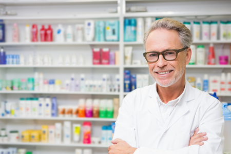 Senior pharmacist smiling at camera at the hospital pharmacyの写真素材