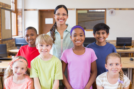 Cute pupils in computer class with teacher at the elementary school